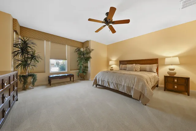 a bedroom with a bed a couch and a chandelier