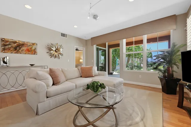 a living room with furniture a flat screen tv and a large window