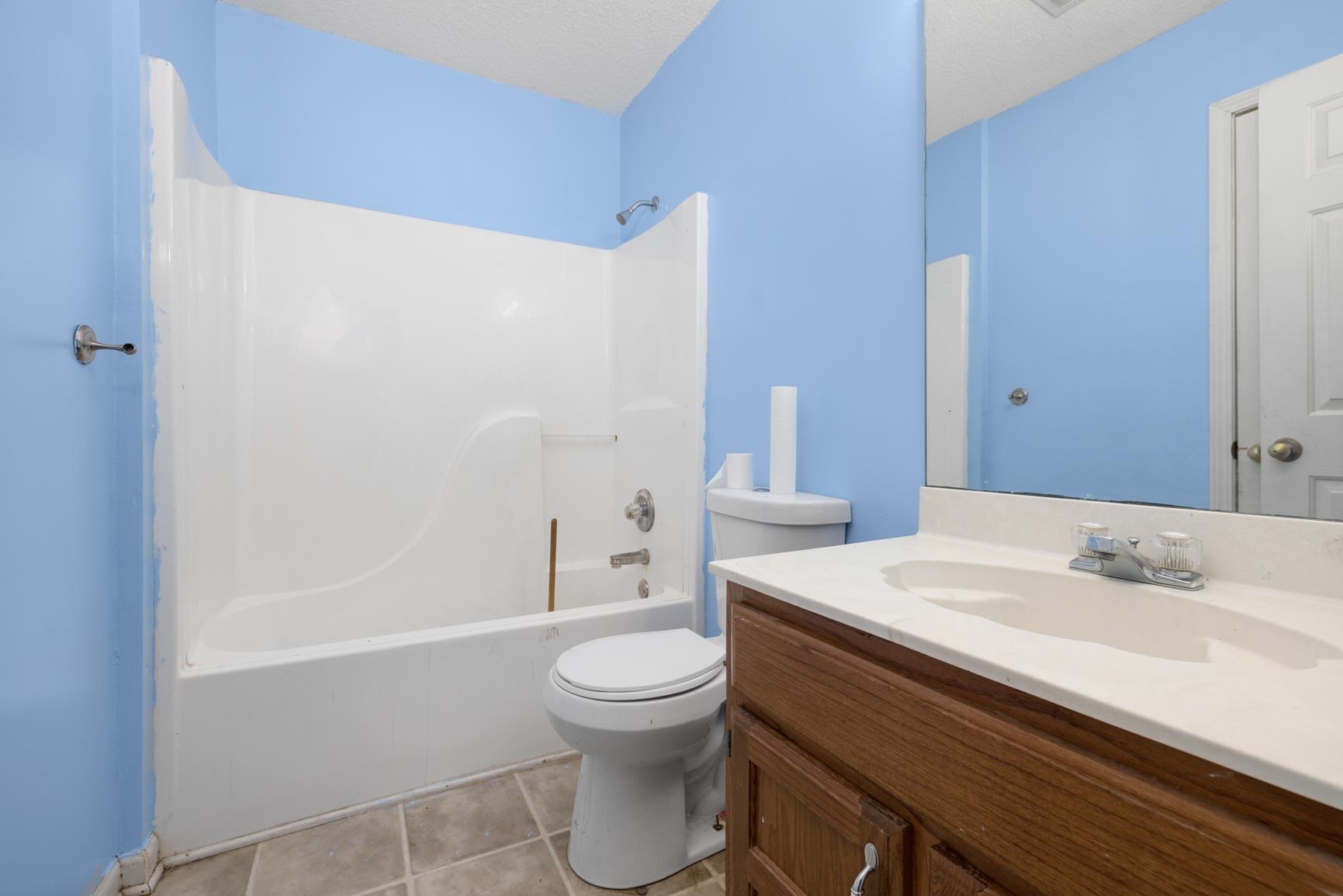 275 Morris Road Covington, TN 38019 - Photo 29 of 32 Full bathroom featuring vanity, bathtub / shower combination, tile patterned flooring, toilet, and a textured ceiling