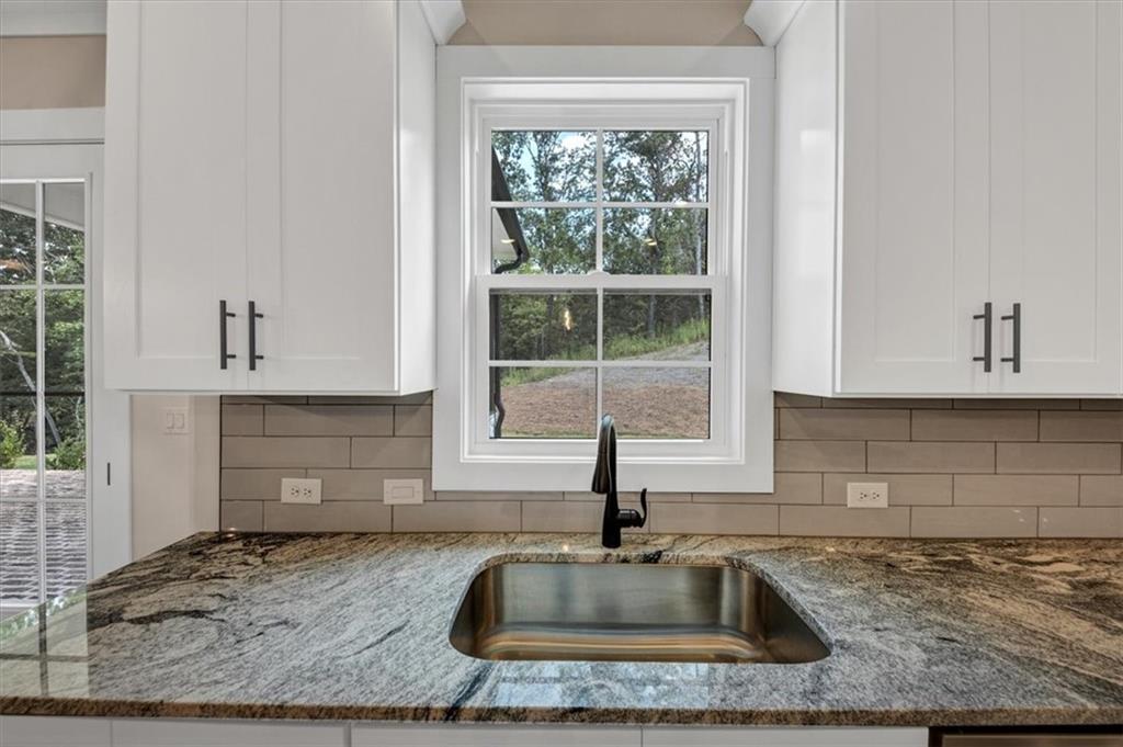 388 Oxford Road Ball Ground, GA 30107 - Photo 15 of 55 a kitchen with granite countertop a sink and a window