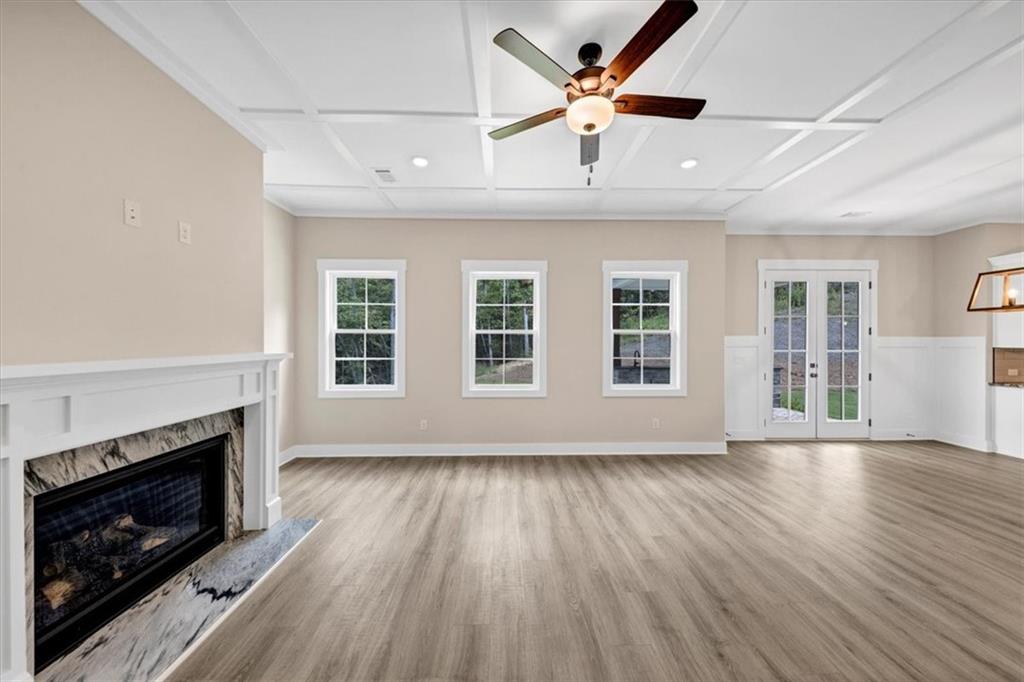 388 Oxford Road Ball Ground, GA 30107 - Photo 19 of 55 an empty room with wooden floor fireplace cabinet and windows