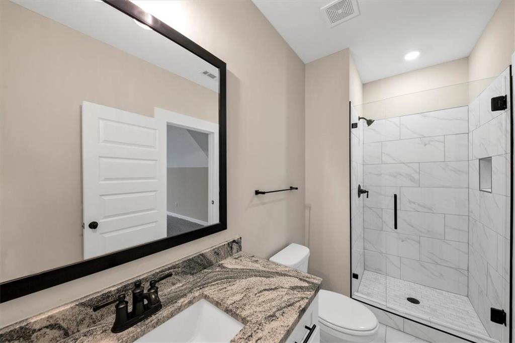 388 Oxford Road Ball Ground, GA 30107 - Photo 43 of 55 a bathroom with a granite countertop sink toilet and shower