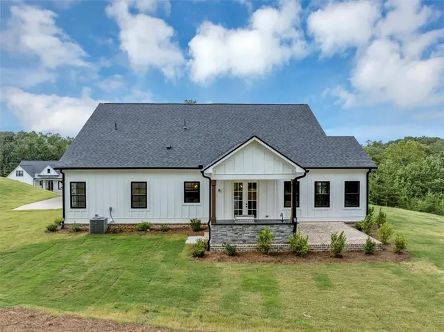 a white house covered with tall trees