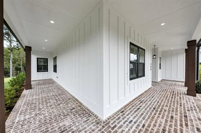 a view of a hallway with wooden floor and a living room