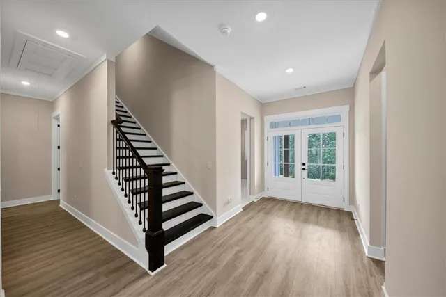 a large kitchen with stainless steel appliances kitchen island granite countertop a stove a refrigerator a sink and dishwasher with wooden floor