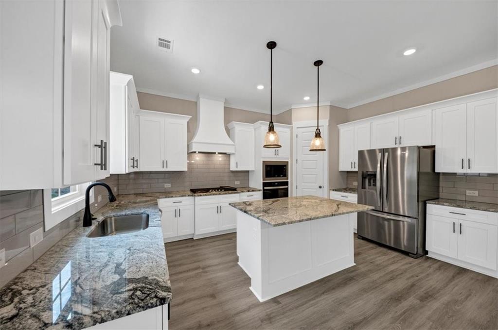 388 Oxford Road Ball Ground, GA 30107 - Photo 10 of 55 a large kitchen with stainless steel appliances kitchen island granite countertop a stove a refrigerator a oven and a sink with large countertops