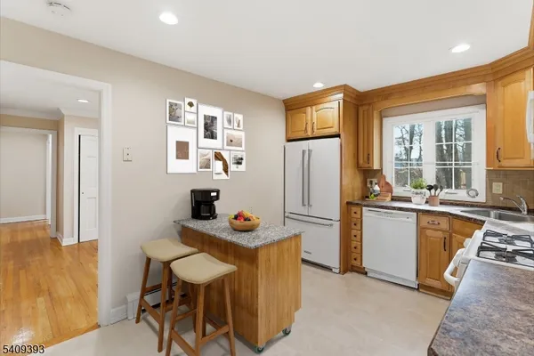 a kitchen with stainless steel appliances kitchen island granite countertop a refrigerator a stove a sink dishwasher with a dining table and chairs