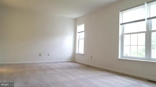 an empty room with an entryway and a window