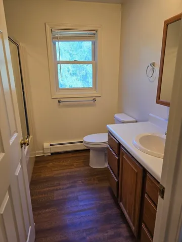 a bathroom with a sink a toilet a mirror and shower