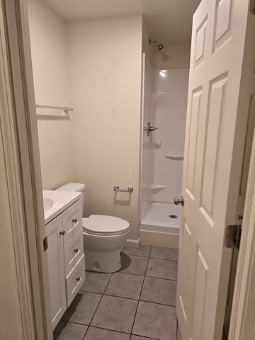 a bathroom with a granite countertop toilet a sink and a shower