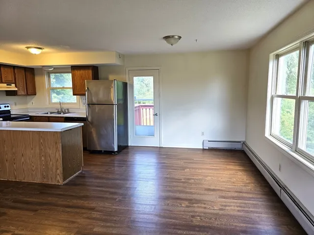 a kitchen with stainless steel appliances a refrigerator and wooden floor