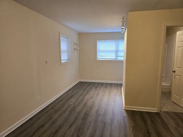 a view of a room with wooden floor and a window