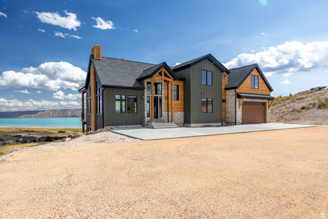 300 Knoll Loop, Unit 227 Fish Haven, ID 83287 - Photo 2 of 56 View of front of property with board and batten siding, driveway, stone siding, and a chimney