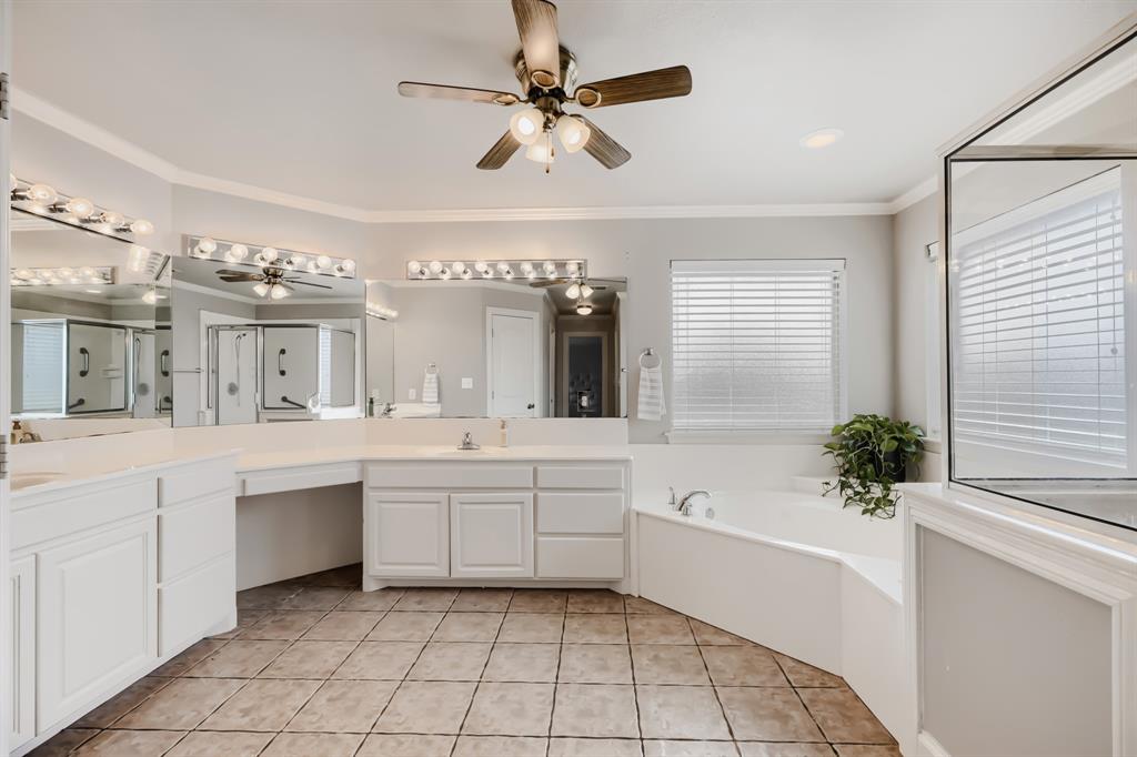 603 Ash Street Pilot Point, TX 76258 - Photo 20 of 28 Spacious bathroom featuring an expansive double vanity with white cabinetry, a built-in makeup desk, and a large soaking tub