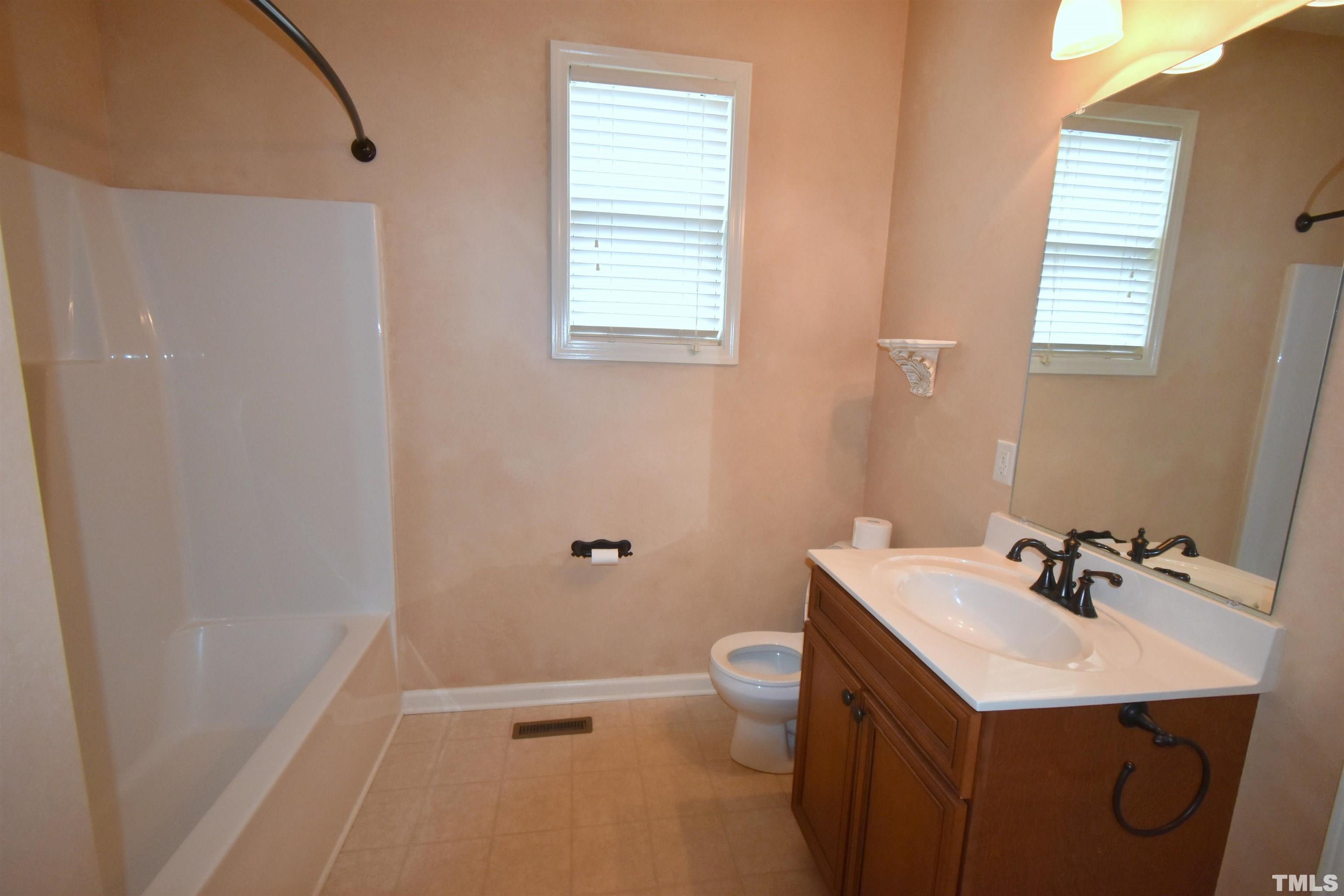 2019 Sinclair Trace Burlington, NC 27215 - Photo 16 of 32 a bathroom with a sink a toilet and a window