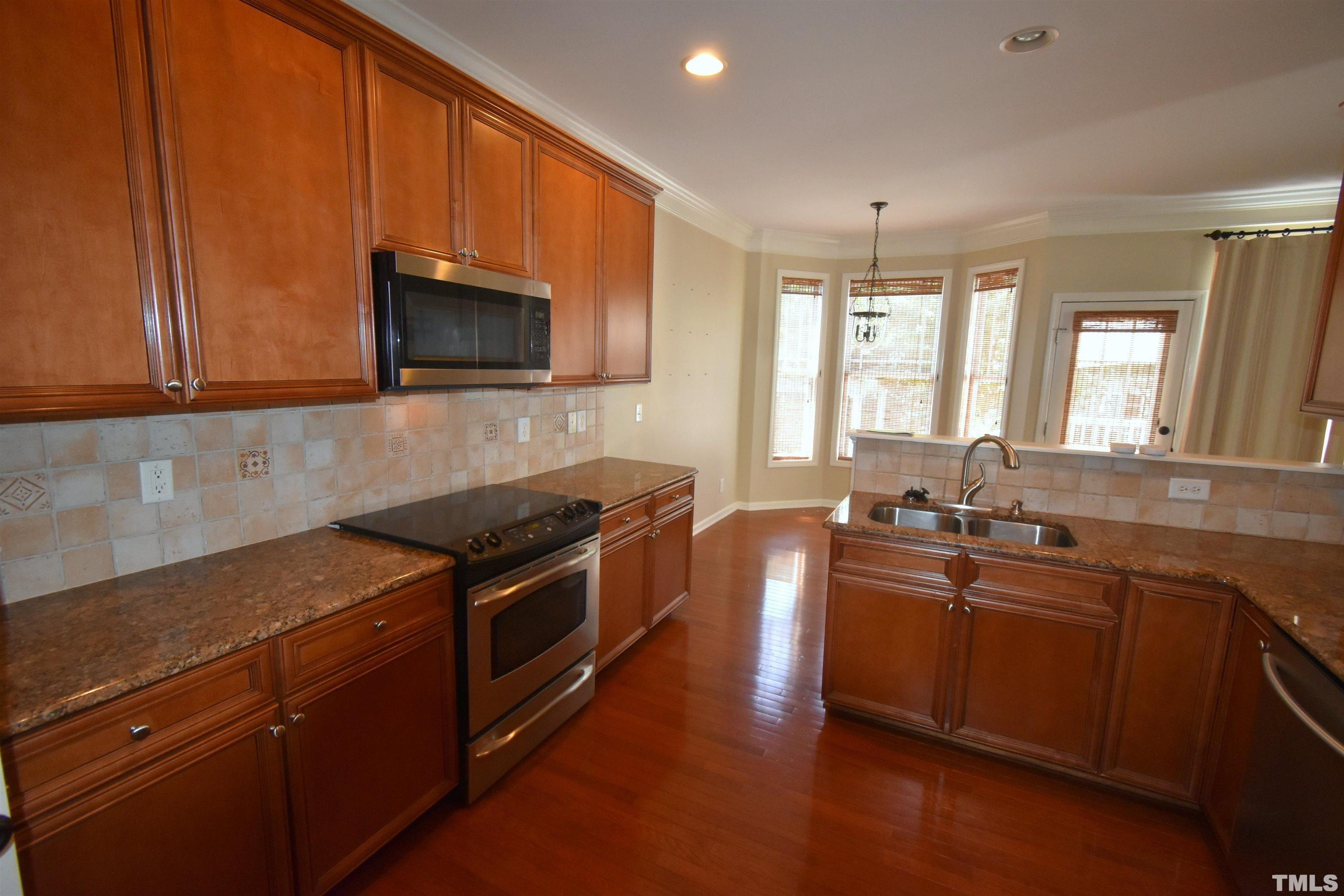 2019 Sinclair Trace Burlington, NC 27215 - Photo 7 of 32 a kitchen with granite countertop wooden cabinets and a stove top oven