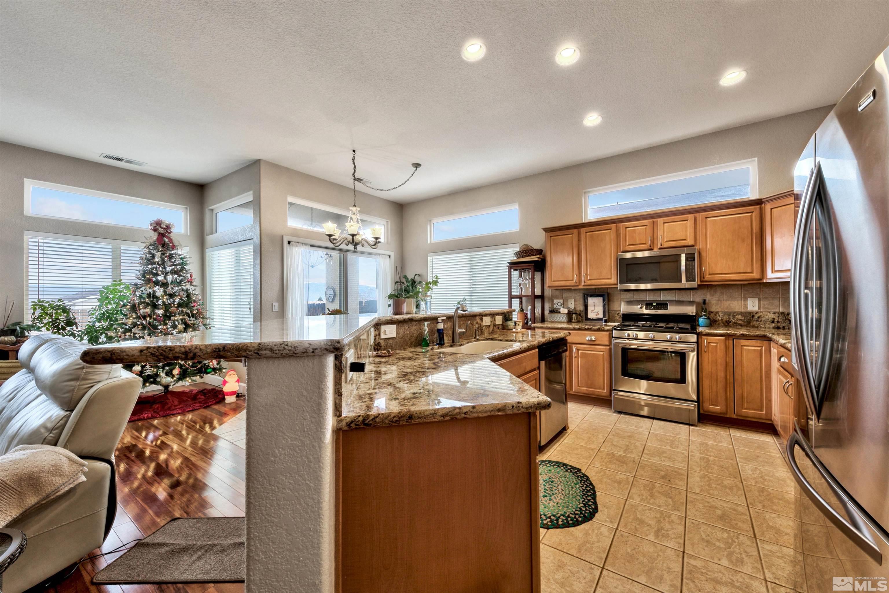 2831 Longridge Drive Carson City, NV 89706 - Photo 11 of 27 a kitchen with stainless steel appliances granite countertop a stove a sink and a refrigerator