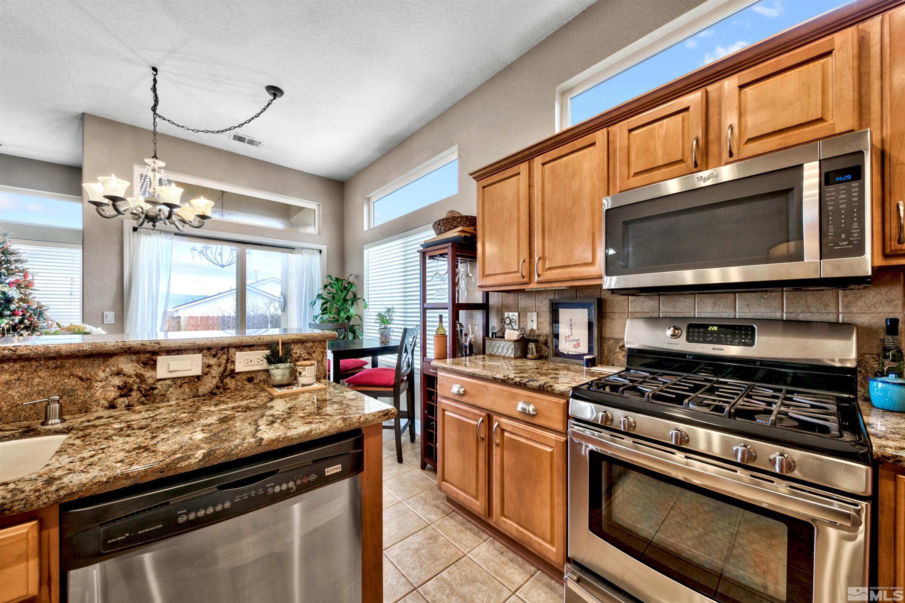 2831 Longridge Drive Carson City, NV 89706 - Photo 14 of 27 a kitchen with stainless steel appliances granite countertop a stove and a microwave