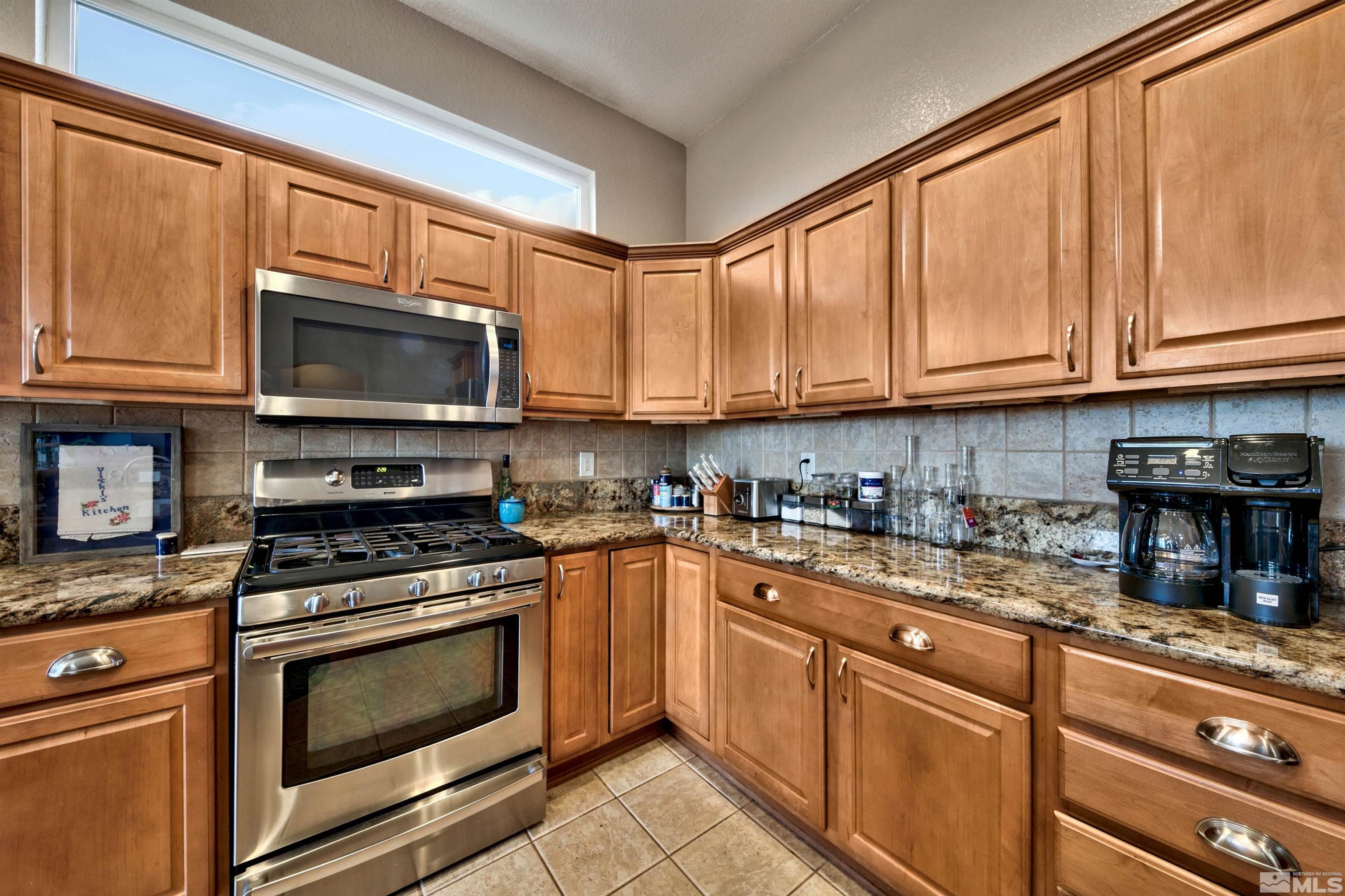 2831 Longridge Drive Carson City, NV 89706 - Photo 15 of 27 a kitchen with stainless steel appliances granite countertop a stove top oven a sink and dishwasher a refrigerator with wooden cabinets