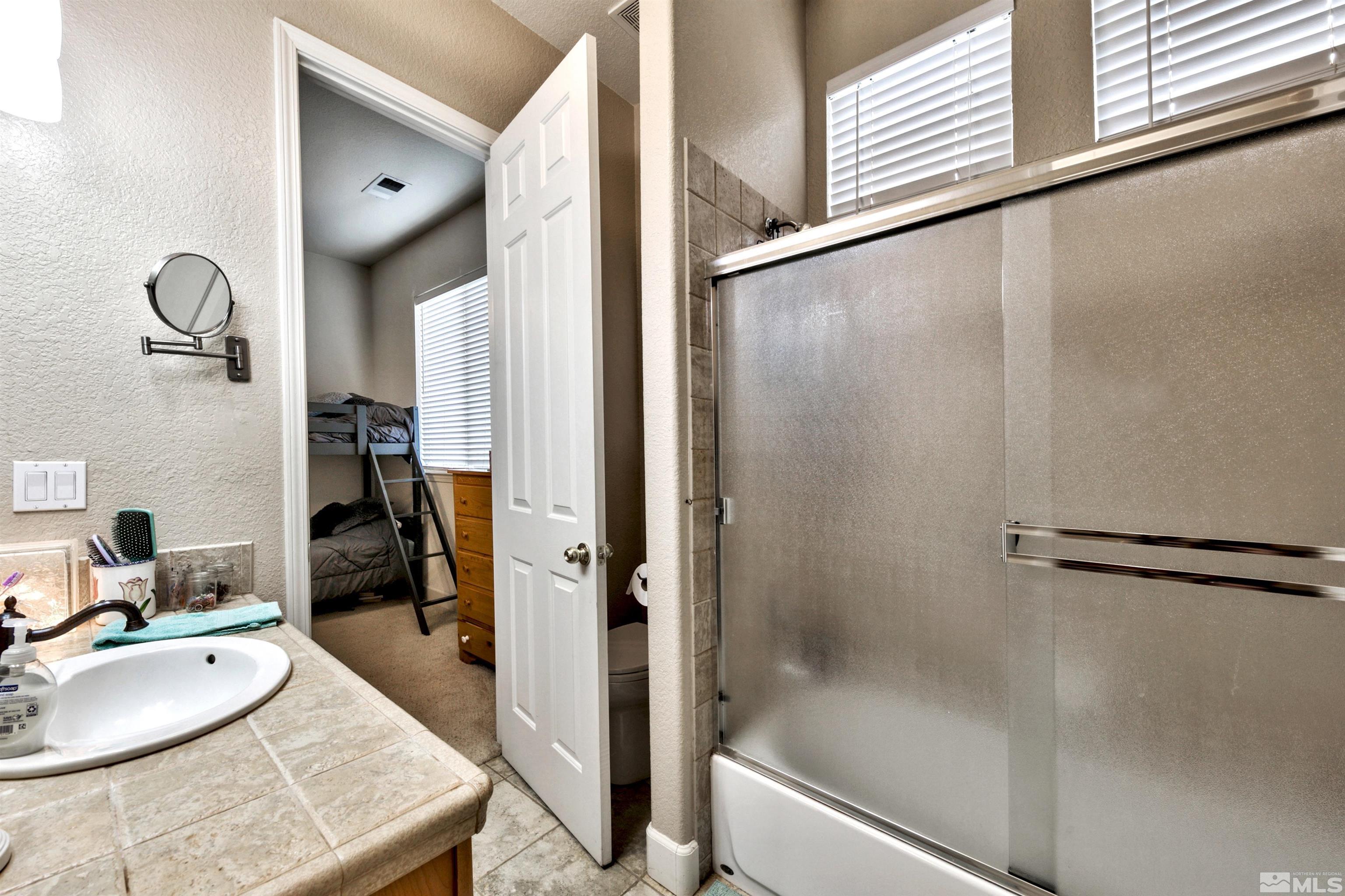 2831 Longridge Drive Carson City, NV 89706 - Photo 23 of 27 a bathroom with a granite countertop sink and a mirror