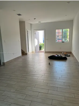 a view of a livingroom with wooden floor and a window