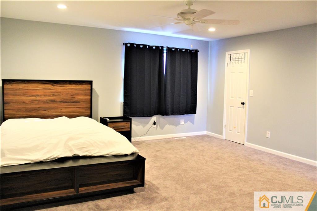 8001 Hana Road Edison, NJ 08817 - Photo 14 of 25 a bedroom with a bed and a dresser