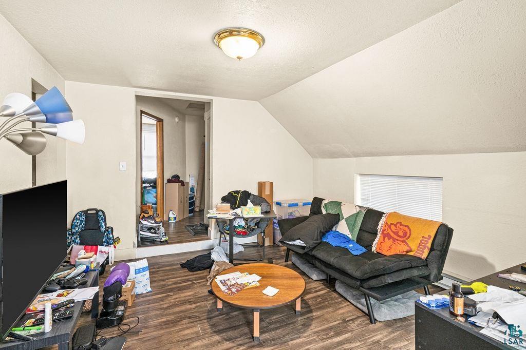 628 West 3rd Street Duluth, MN 55806 - Photo 2 of 8 Living area featuring a textured ceiling, wood finished floors, and vaulted ceiling