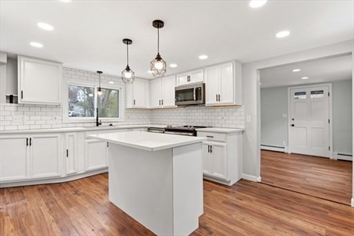 18 Wainwright Avenue Haverhill, MA 01835 - Photo 4 of 10 a kitchen with kitchen island granite countertop a sink cabinets and wooden floor