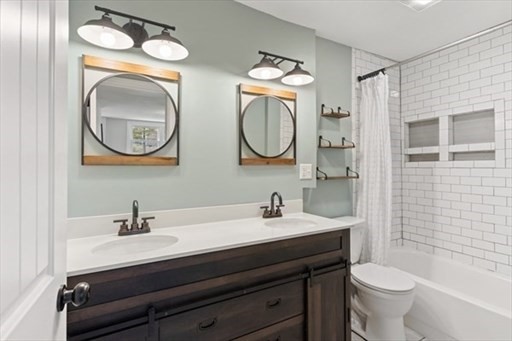18 Wainwright Avenue Haverhill, MA 01835 - Photo 8 of 10 a bathroom with a toilet a sink and a mirror