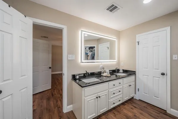 a bathroom with a granite countertop sink and a mirror