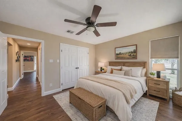 a bedroom with a bed and painting on the wall