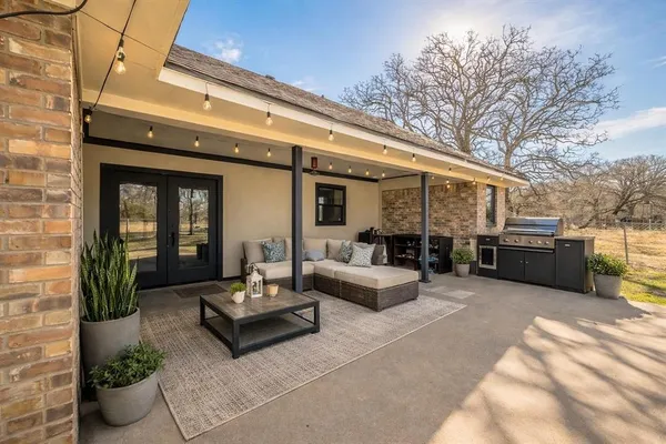 a view of a patio with couches table and chairs and potted plants