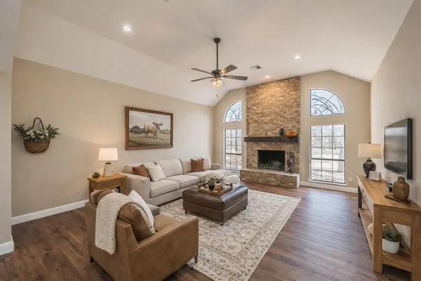 a living room with furniture a fireplace and a flat screen tv