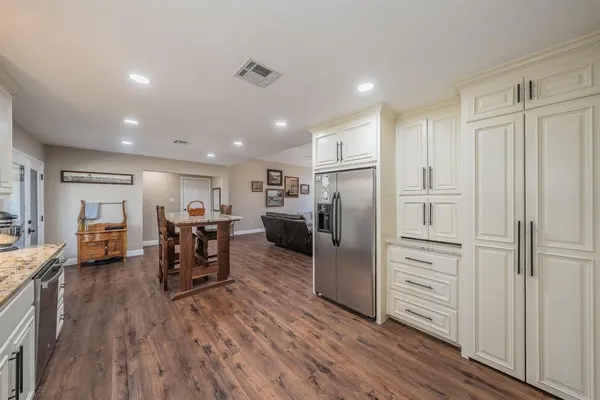 a kitchen with stainless steel appliances a refrigerator and wooden floor