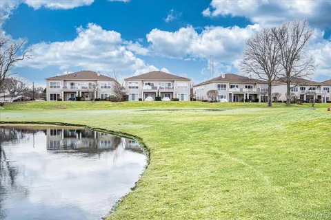 a view of swimming pool and a yard in front of the house