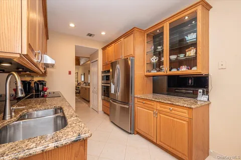 a kitchen with granite countertop a refrigerator and a stove top oven