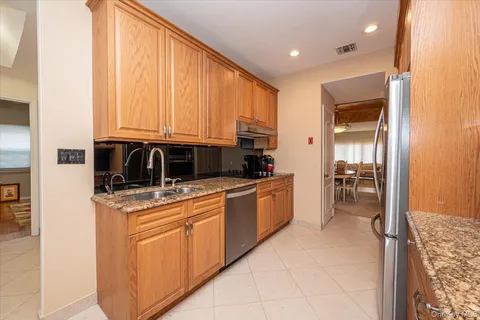 a kitchen with stainless steel appliances granite countertop a stove a sink and a microwave