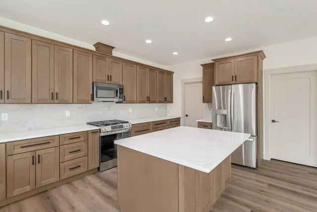 a kitchen with white cabinets and stainless steel appliances