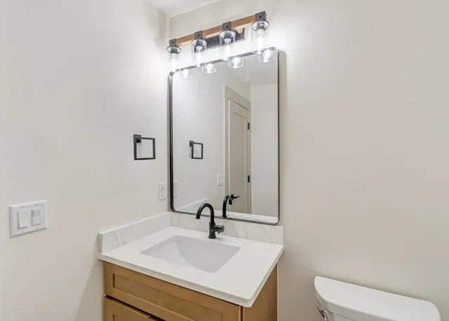 a bathroom with a sink a toilet and mirror