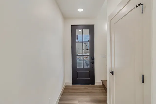 a view of a hallway with wooden floor and entryway