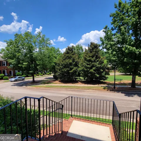 a view of an empty room with wooden floor and a chandelier