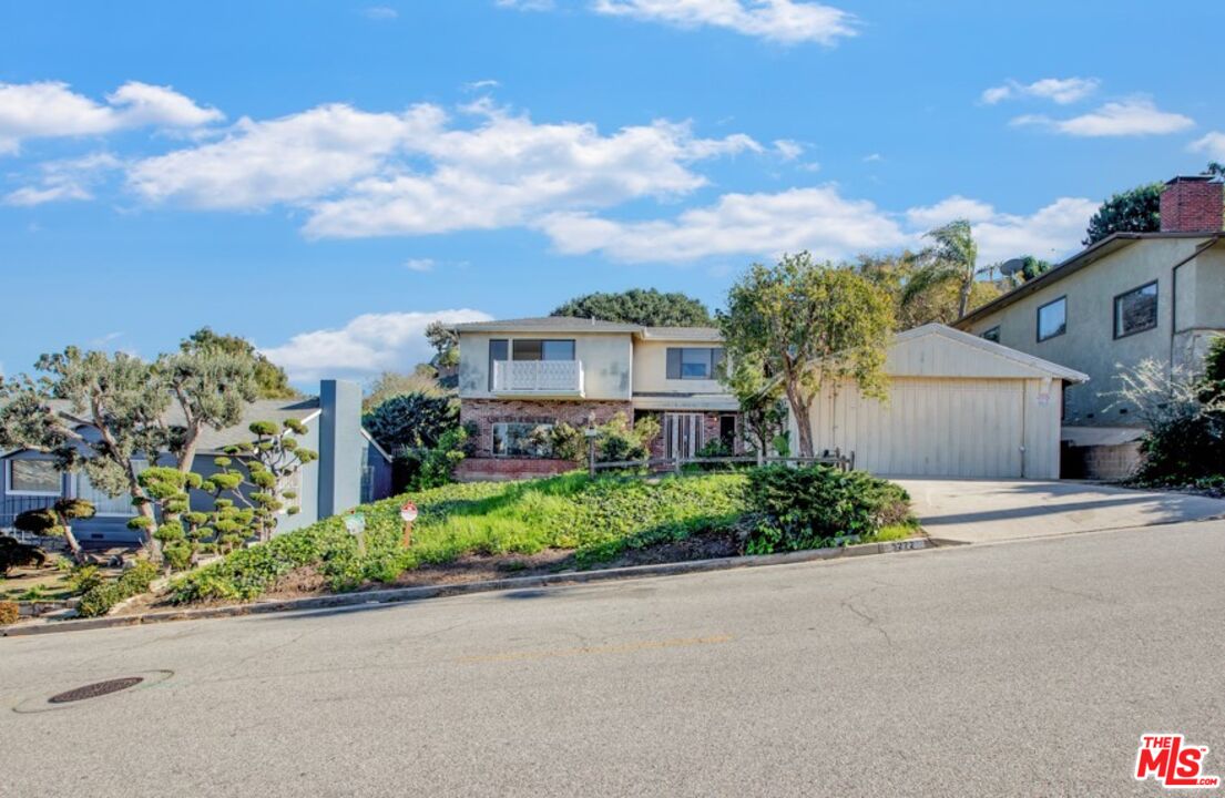 front view of a house with a yard and potted plants