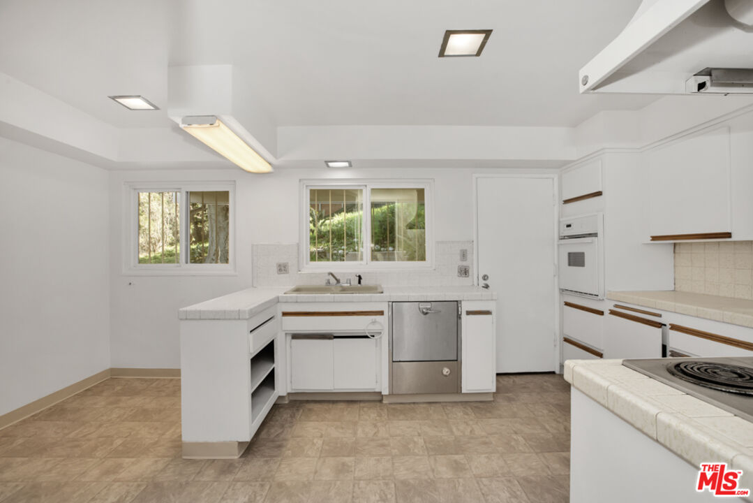 5272 Veronica Street Los Angeles, CA 90008 - Photo 18 of 51 a kitchen with white cabinets and white appliances