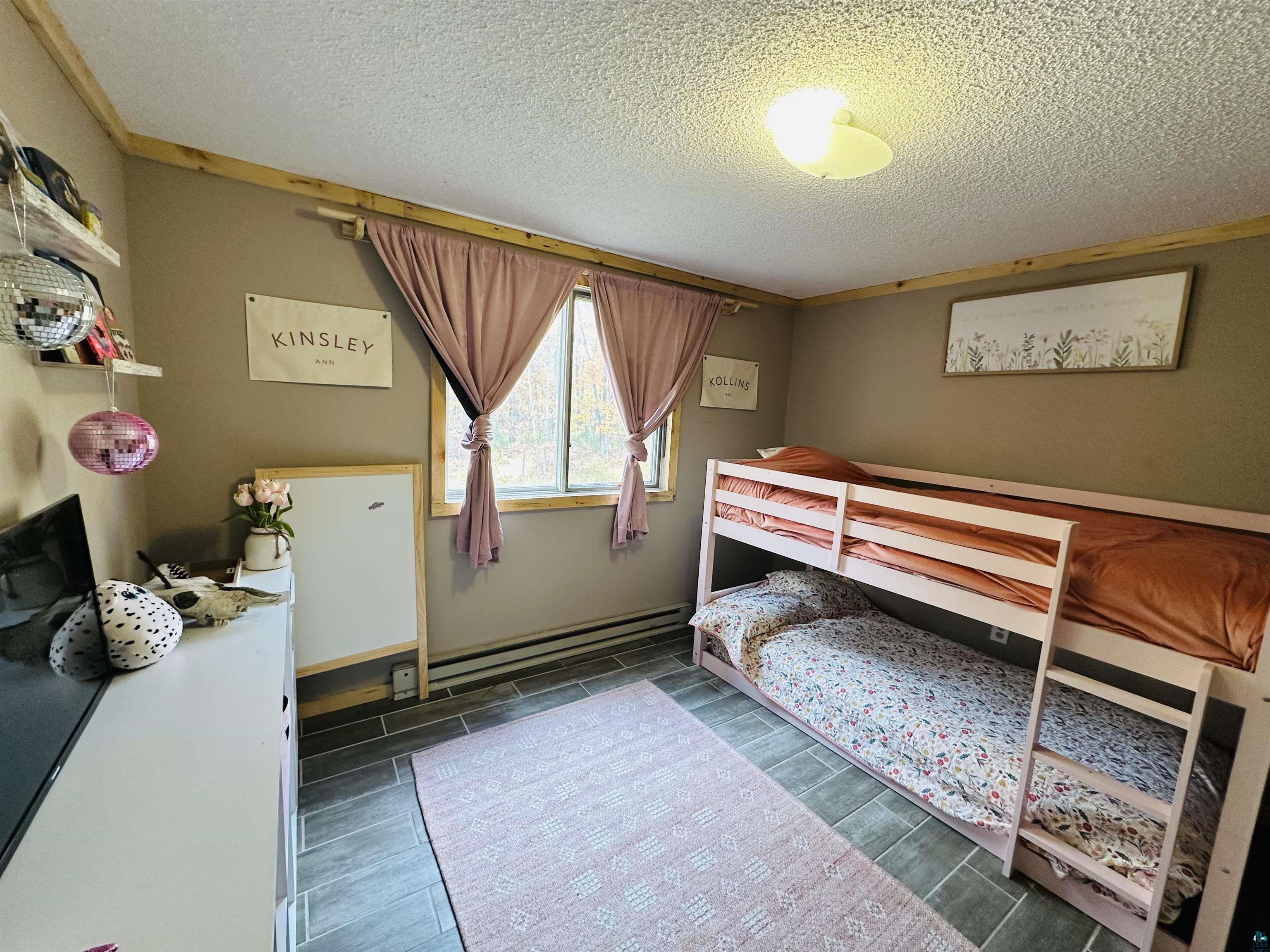 6955 Kolling Road Iron River, WI 54847 - Photo 6 of 22 Bedroom featuring a textured ceiling, wood tiled floors, and baseboard heating