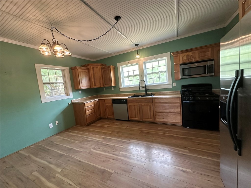 131 Dell Street Portland, TX 78374 - Photo 12 of 40 a kitchen with stainless steel appliances granite countertop a sink cabinets and wooden floor