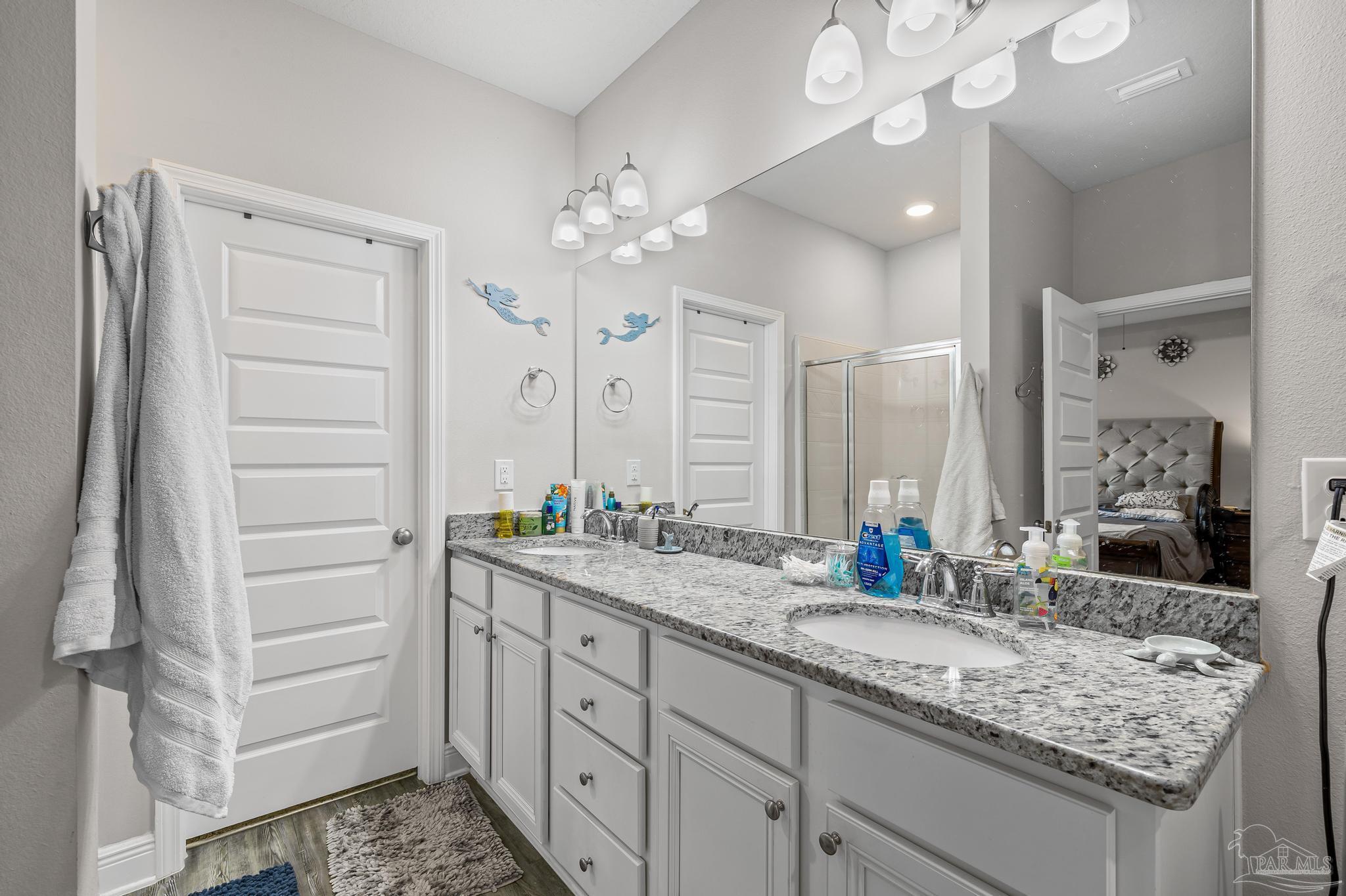 5375 Red Shoulder Road Pace, FL 32571 - Photo 22 of 40 a bathroom with a granite countertop sink a large mirror and a shower