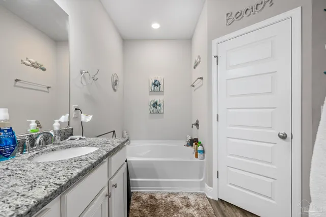 a bathroom with a granite countertop sink a large mirror and a shower
