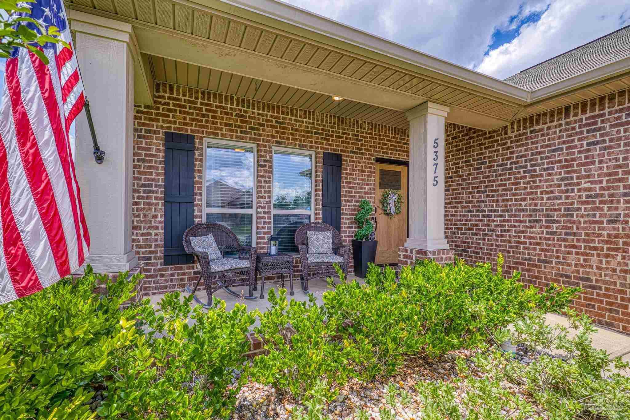 5375 Red Shoulder Road Pace, FL 32571 - Photo 30 of 40 a front view of a house with garden and patio
