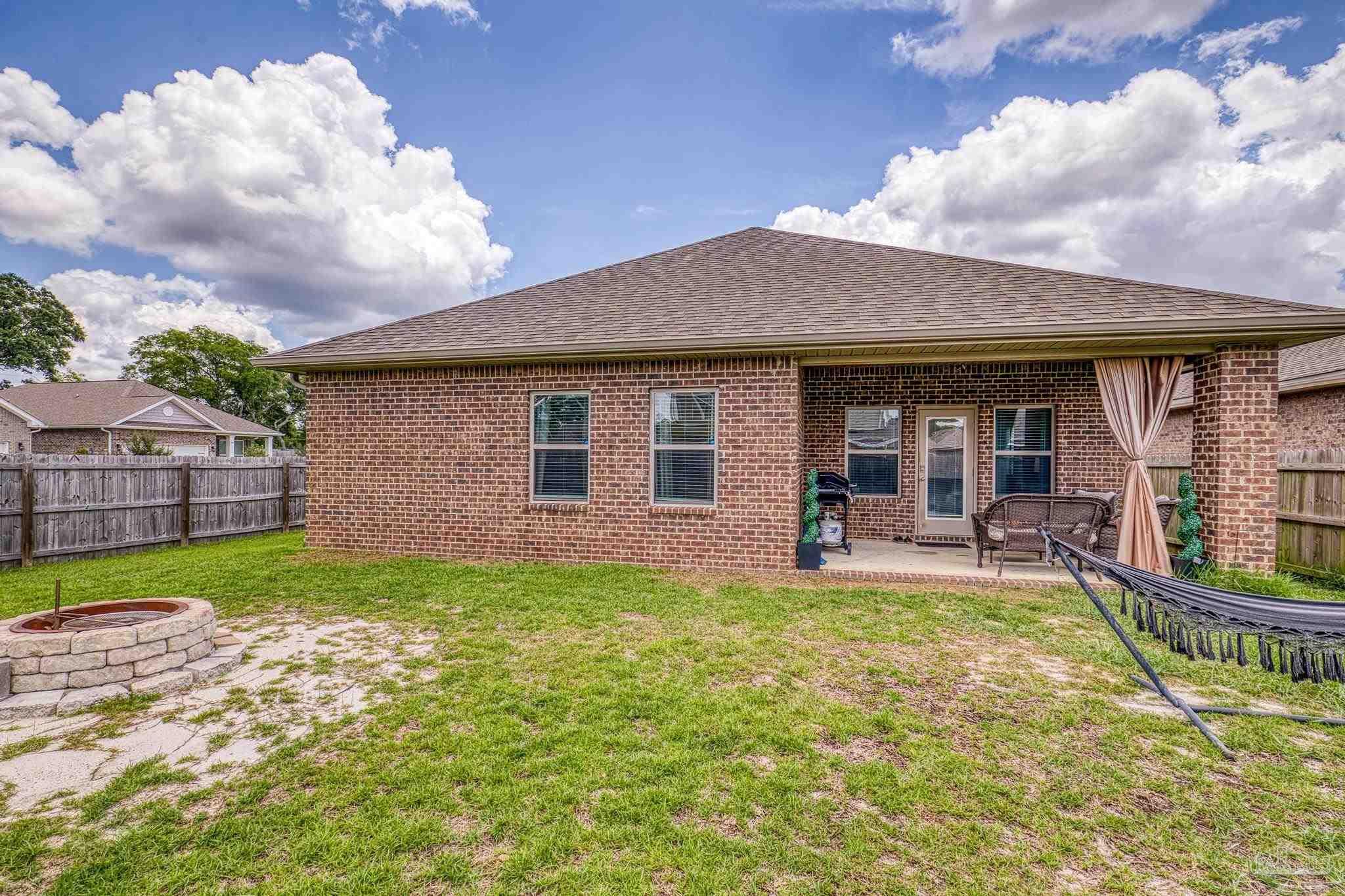 5375 Red Shoulder Road Pace, FL 32571 - Photo 34 of 40 a view of a house with a yard potted plants and a table and chairs
