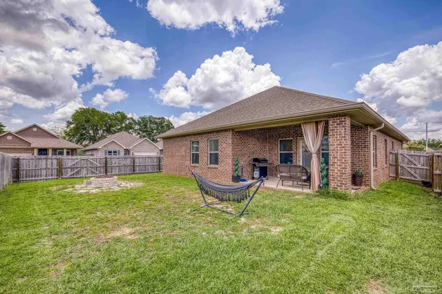 a view of a house with a yard potted plants and a table and chairs